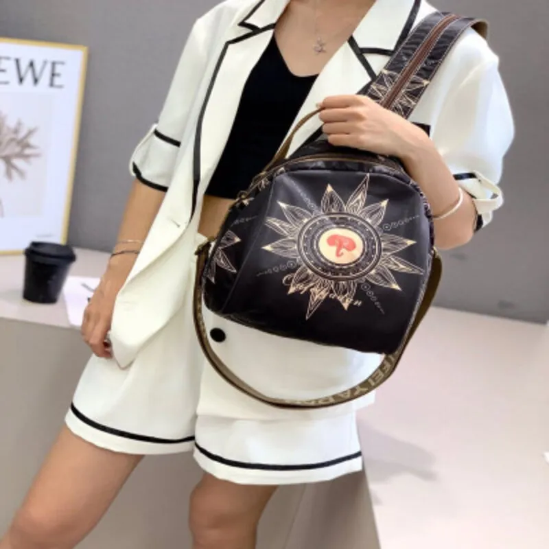 Trendy women’s black backpack with stylish prints, zipper pockets, and extra strapشنطة ظهر نسائية بتصميم عصري باللون الأسود مع جيوب بسحاب وحزام إضافي